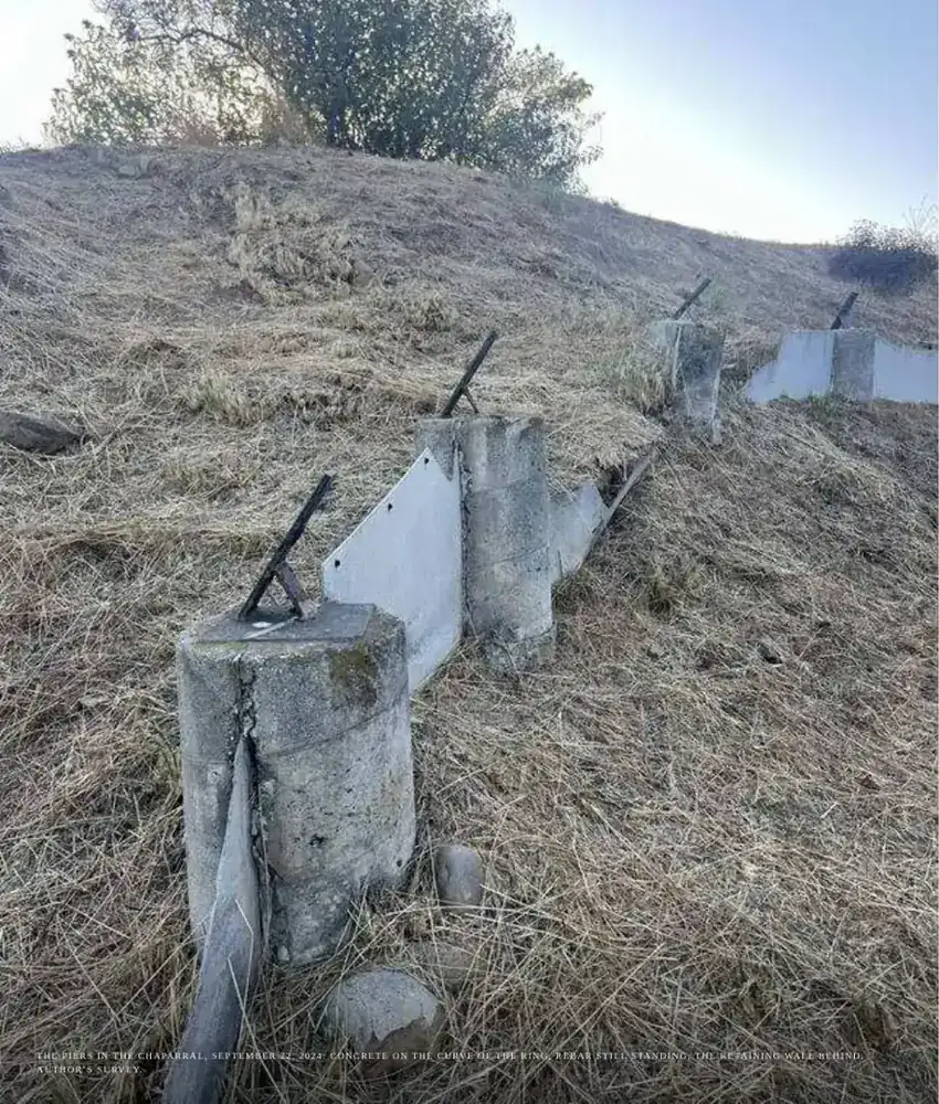 Weathered concrete piers in dry grass on a hillside